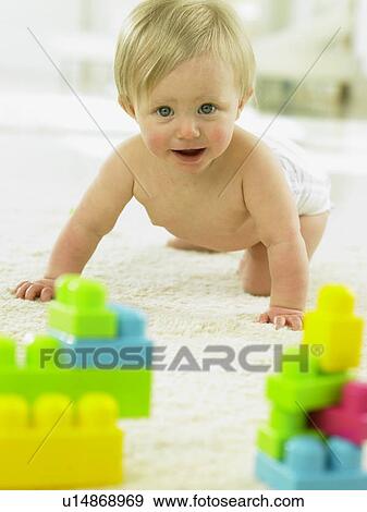 Baby crawling towards plastic blocks View Large Photo Image Stock Photo - Baby crawling towards plastic blocks. Fotosearch