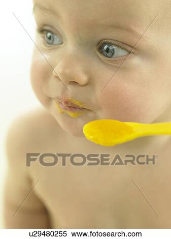 Stock Photography - Baby eating baby food from spoon. Fotosearch