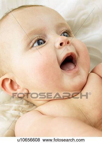 Stock Photo - Baby laying down with mouth open. Fotosearch