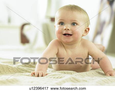 Baby laying on a sweater smiling View Large Photo Image Stock Photo - Baby laying on a sweater smiling. Fotosearch