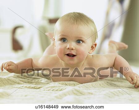 Stock Photo - Baby laying on a sweater smiling. Fotosearch