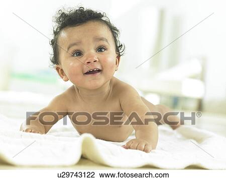 Baby laying on a towel smiling View Large Photo Image Stock Image - Baby laying on a towel smiling. Fotosearch