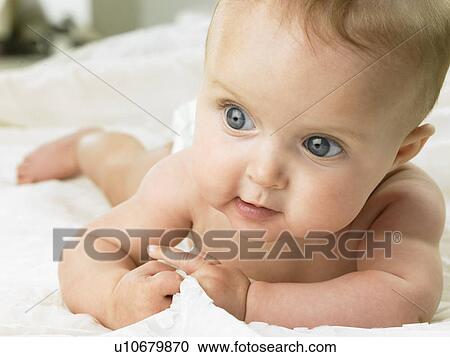 Baby laying on white sheet View Large Photo Image Stock Image - Baby laying on white sheet. Fotosearch