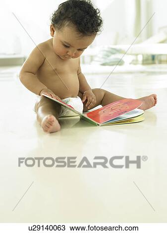 Stock Image - Baby looking at book. Fotosearch