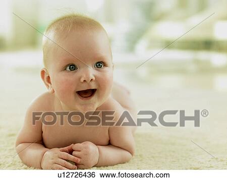 Baby lying on floor smiling View Large Photo Image Stock Photograph - Baby lying on floor smiling. Fotosearch