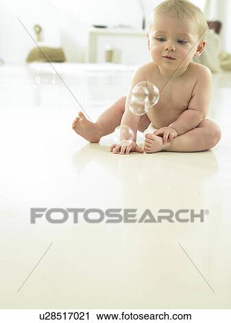 Stock Image - Baby playing with bubbles. Fotosearch