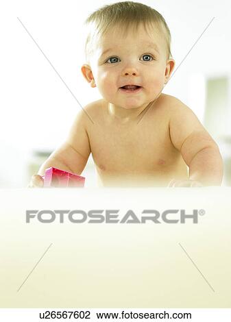 Stock Image - Baby playing with plastic block. Fotosearch