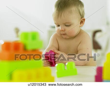 Stock Image - Baby playing with plastic blocks. Fotosearch
