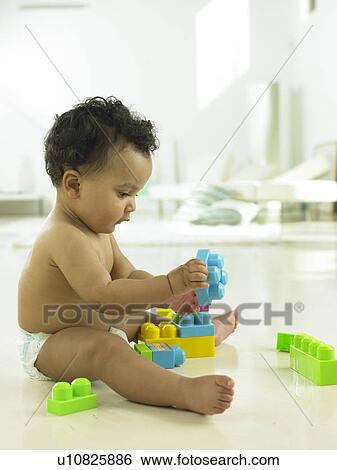 Stock Photograph - Baby playing with plastic blocks. Fotosearch