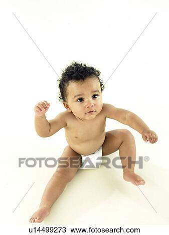 Stock Image - Baby sitting looking up at camera. Fotosearch