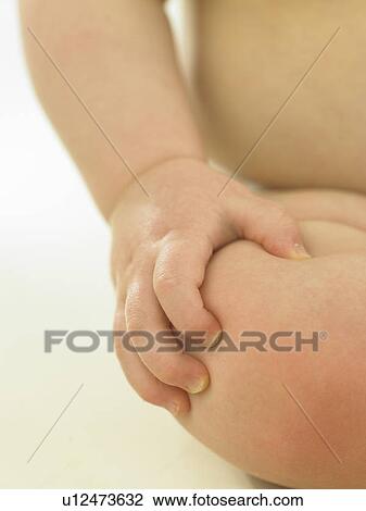 Baby sitting with hand on knee View Large Photo Image Stock Image - Baby sitting with hand on knee. Fotosearch