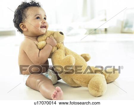 Picture - Baby sitting with teddy bear. Fotosearch