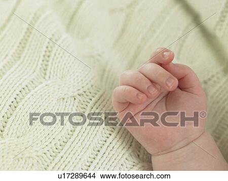 Picture - Baby's hand resting on a blanket. Fotosearch