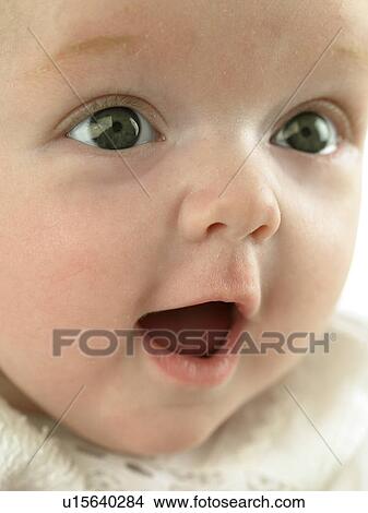 Picture - Baby's face close up looking surprised. Fotosearch