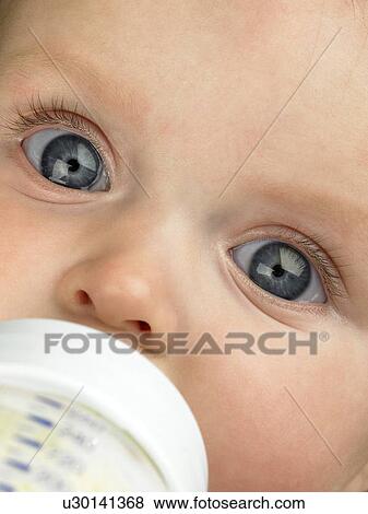 Baby's face close up with baby bottle View Large Photo Image Stock Photo - Baby's face close up with baby bottle. Fotosearch