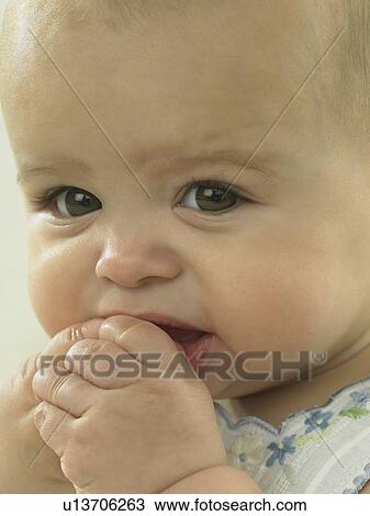Baby's face close up with hands by mouth View Large Photo Image Stock Image - Baby's face close up with hands by mouth. Fotosearch