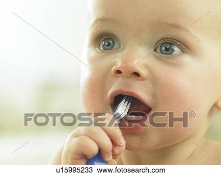 Stock Image - Baby's with toothbrush in mouth. Fotosearch