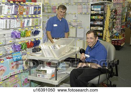 A man with a disability, utilizing a wheelchair for mobility, enjoying time with a coworker in a retail store. View Large Photo Image Stock Image - A man with a disability, utilizing a wheelchair for mobility, enjoying time with a coworker in a retail store.. Fotosearch