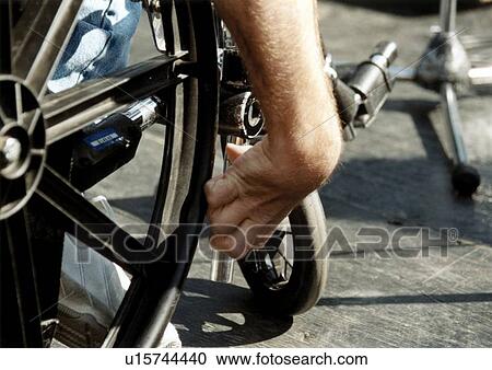 Stock Image - Image of a man's hand as he moves his wheelchair to get to where he wants to go.. Fotosearch
