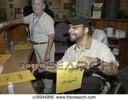 Man with a disability, utilizing a wheelchair for mobility, visiting an exhibit. View Large Photo Image Stock Photograph - Man with a disability, utilizing a wheelchair for mobility, visiting an exhibit.. Fotosearch