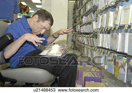 Man with multiple disabilities working with cards in a retail store. View Large Photo Image Stock Image - Man with multiple disabilities working with cards in a retail store.. Fotosearch
