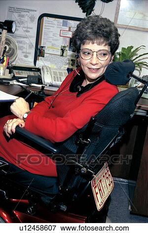 Stock Photo - Professional woman with a disability performing her routine daily to-do list. She just happens to utilize a scooter/cart for mobility.. Fotosearch