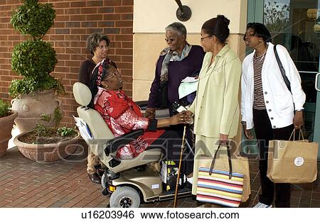 Several women talking and laughing with a woman with a disability utilizing a scooter for mobility. View Large Photo Image Stock Photograph - Several women talking and laughing with a woman with a disability utilizing a scooter for mobility.. Fotosearch