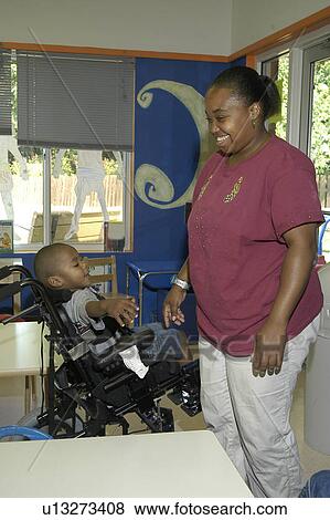 Stock Photo - Student with a disability sharing a special moment with his teacher.. Fotosearch