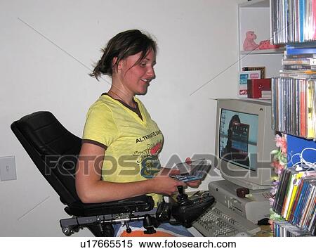 Woman using an electric wheelchair files computer discs at her workstation. View Large Photo Image Stock Photography - Woman using an electric wheelchair files computer discs at her workstation.. Fotosearch