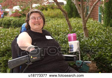 Woman with physical disabilities heading to a meeting in her motorized wheelchair. View Large Photo Image Stock Photo - Woman with physical disabilities heading to a meeting in her motorized wheelchair.. Fotosearch