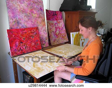 Young artist (female wheelchair user) applies paint to canvas with her fingers. View Large Photo Image Picture - Young artist (female wheelchair user) applies paint to canvas with her fingers.. Fotosearch