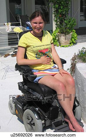 Young woman (electric wheelchair user) enjoys the sun outside her home. View Large Photo Image Stock Photograph - Young woman (electric wheelchair user) enjoys the sun outside her home.. Fotosearch