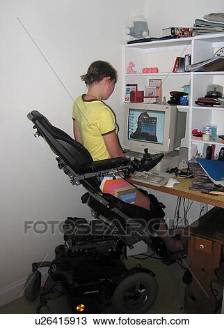 Young woman uses electric wheelchair w/elevating feature to access computer workstation. View Large Photo Image Stock Image - Young woman uses electric wheelchair w/elevating feature to access computer workstation.. Fotosearch