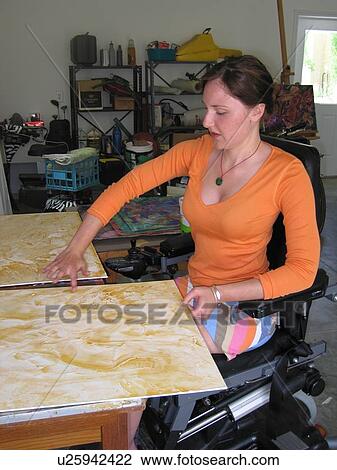 Young woman (wheelchair user) uses fingers to apply oil to canvas in her studio. View Large Photo Image Stock Image - Young woman (wheelchair user) uses fingers to apply oil to canvas in her studio.. Fotosearch