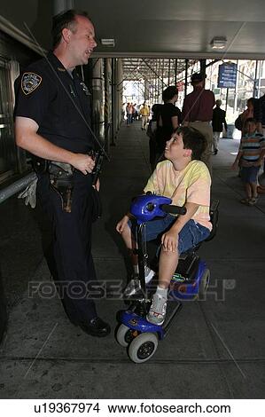 A boy on a scooter talking with a New York City police officer. View Large Photo Image Picture - A boy on a scooter talking with a New York City police officer.. Fotosearch