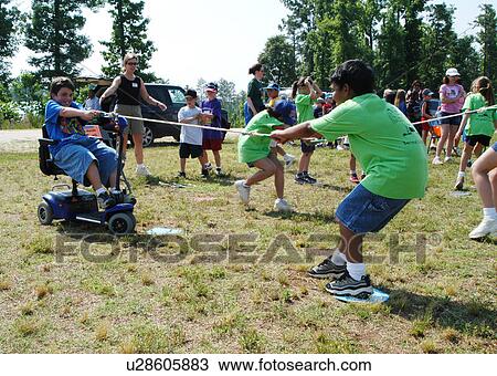 A classic game of tug-of-war. This time, however, a boy with a disability, with the assistance of his scooter/cart are the sole team members on his end of the rope! View Large Photo Image Stock Image - A classic game of tug-of-war. This time, however, a boy with a disability, with the assistance of his scooter/cart are the sole team members on his end of the rope!. Fotosearch