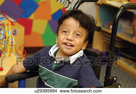 Picture - Absolutely adorable little boy with a disability with a precious smile on his face, with a colorful background.. Fotosearch