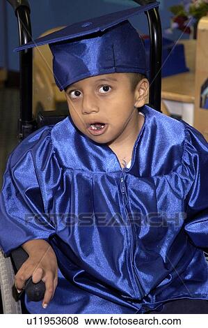 Stock Photo - Adorable little boy with multiple disabilities impatiently awaiting the start of his preschool graduation ceremony.. Fotosearch