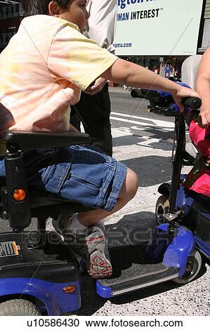 Stock Image - Close up of a child on a scooter.. Fotosearch