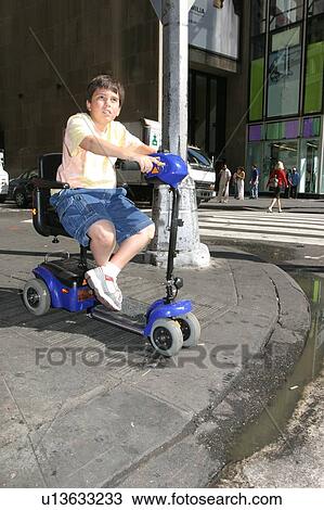 Close up of a child on a scooter using a curb cut. View Large Photo Image Stock Image - Close up of a child on a scooter using a curb cut.. Fotosearch