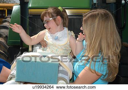 Little girl with multiple disabilities having a blast at a community event. View Large Photo Image Picture - Little girl with multiple disabilities having a blast at a community event.. Fotosearch