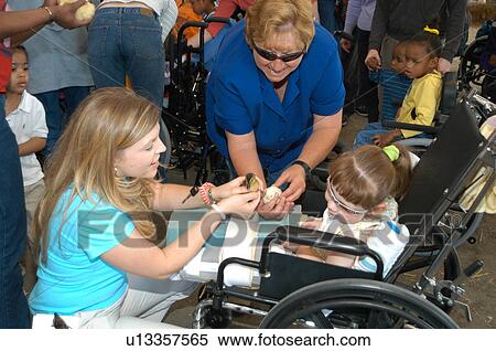 Little girl with multiple disabilities having a good time with her family at a public event. View Large Photo Image Stock Photography - Little girl with multiple disabilities having a good time with her family at a public event.. Fotosearch