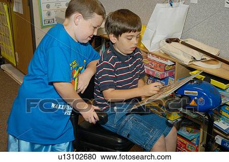 Two boys working on a leisure activity in their classroom. One child has Muscular Dystrophy and utilizes a scooter/cart for mobility. View Large Photo Image Stock Image - Two boys working on a leisure activity in their classroom. One child has Muscular Dystrophy and utilizes a scooter/cart for mobility.. Fotosearch