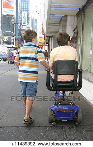 Two brothers, one with a disability, one without, going down a street in New York City. View Large Photo Image Stock Image - Two brothers, one with a disability, one without, going down a street in New York City.. Fotosearch