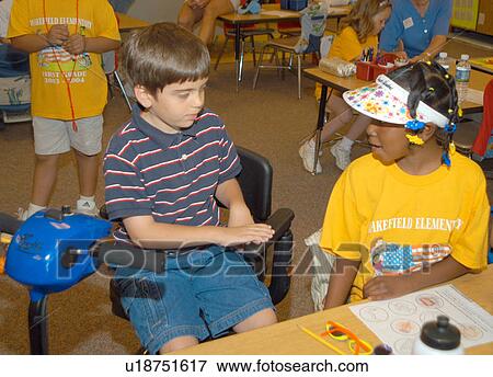 Two classmates working on an art project together. One child has Muscular Dystrophy and utilizes a scooter/cart for mobility. View Large Photo Image Stock Photo - Two classmates working on an art project together. One child has Muscular Dystrophy and utilizes a scooter/cart for mobility.. Fotosearch