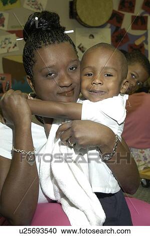 A loving image of a mother and her son with disabilities. Note the brother in the background vying for the camera! View Large Photo Image Stock Image - A loving image of a mother and her son with disabilities. Note the brother in the background vying for the camera!. Fotosearch