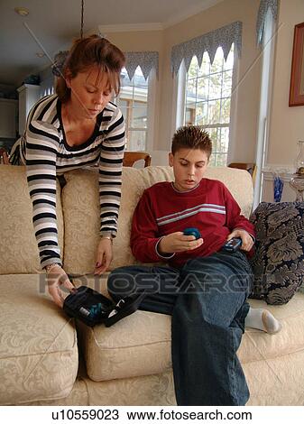 Stock Image - A mother helps son get ready for an insulin reading.. Fotosearch