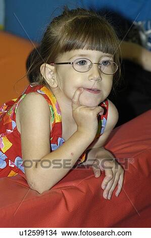 Contemplative face of a little girl with disabilities, including a visual impairment. View Large Photo Image Picture - Contemplative face of a little girl with disabilities, including a visual impairment.. Fotosearch