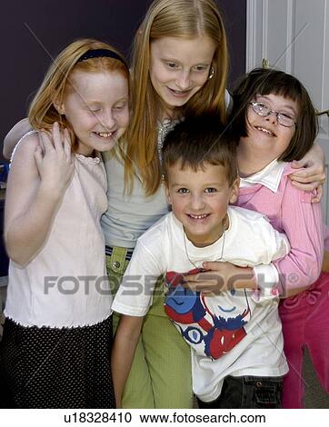 Stock Image - Four siblings, one with a disability, embraced in a ôgroup hugö.. Fotosearch