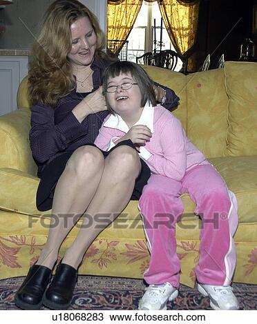Stock Image - Girl with Down Syndrome having a special moment with her Mom.. Fotosearch